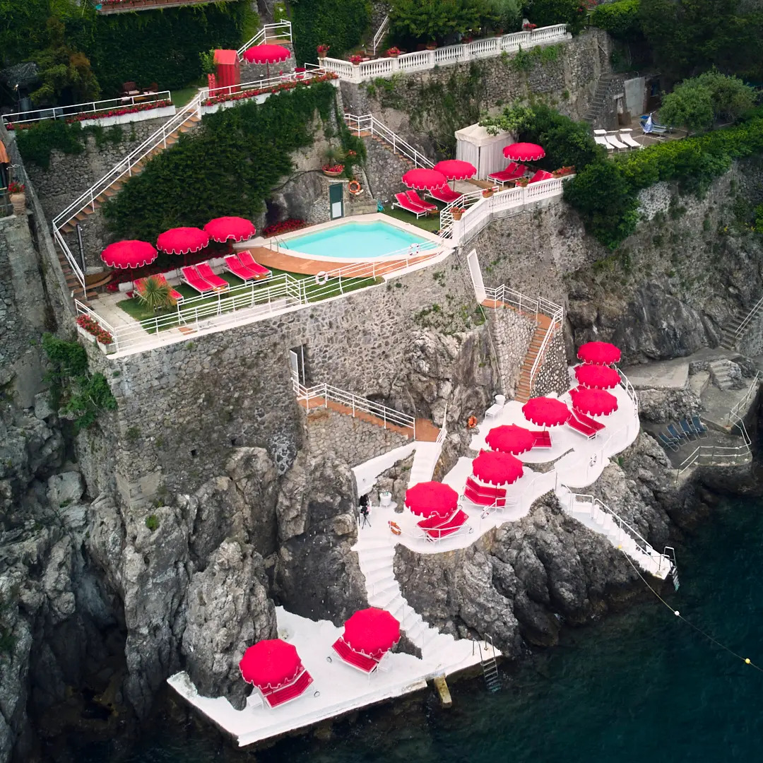 Elegant beach parasols and loungers in a luxury coastal setting, styled like an editorial travel feature